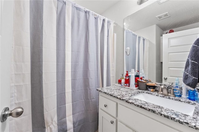 bathroom with curtained shower and vanity