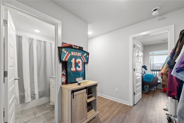 bathroom with shower / bathtub combination with curtain and hardwood / wood-style flooring