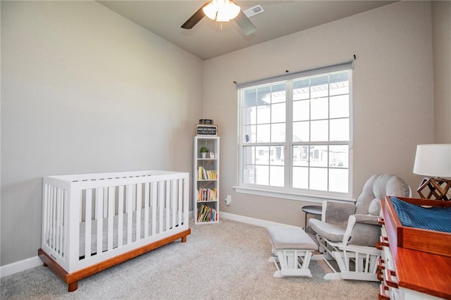 bedroom featuring carpet, ceiling fan, a crib, and vaulted ceiling