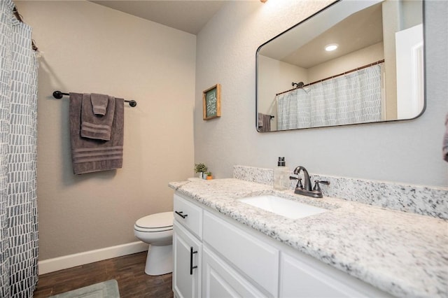 bathroom with wood-type flooring, vanity, toilet, and curtained shower