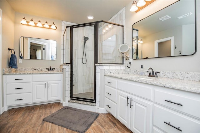 bathroom featuring vanity, a shower with shower door, and hardwood / wood-style flooring