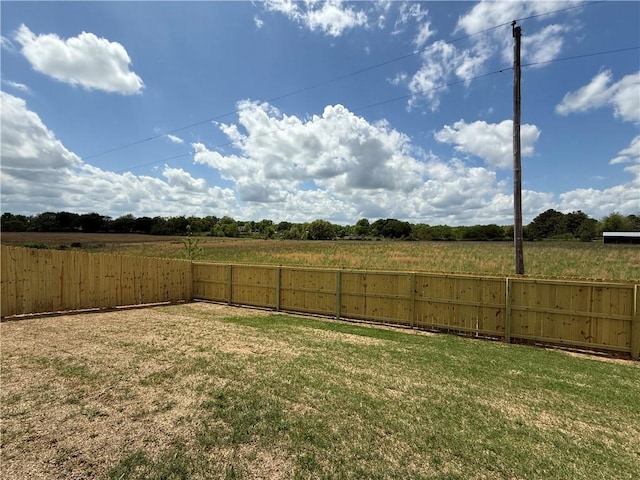 view of yard with a rural view and a fenced backyard