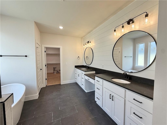bathroom featuring recessed lighting, baseboards, tile patterned flooring, vanity, and a freestanding tub