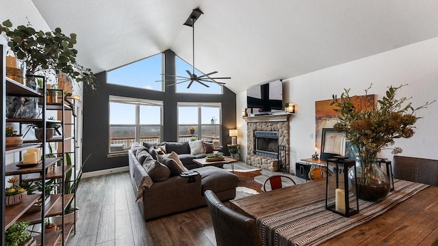 living room featuring wood-type flooring, a stone fireplace, ceiling fan, and lofted ceiling