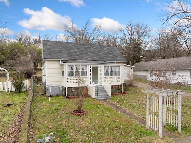 view of front of home with a front yard and central AC unit