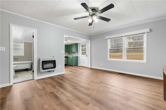 unfurnished living room featuring ceiling fan, light wood-type flooring, heating unit, and crown molding