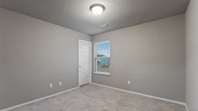 carpeted spare room featuring a textured ceiling