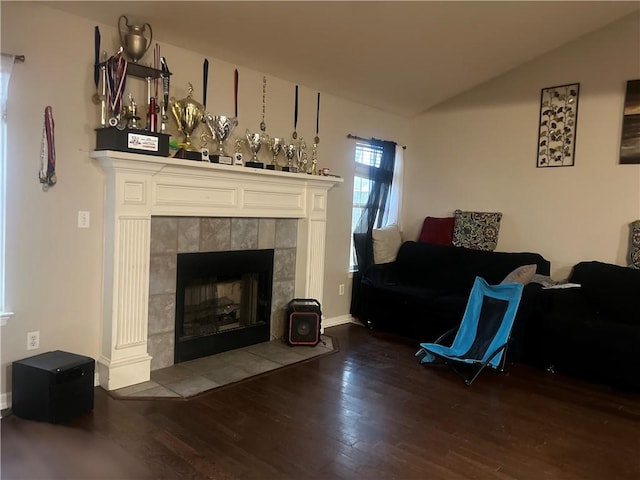 living room featuring hardwood / wood-style floors, a fireplace, and vaulted ceiling