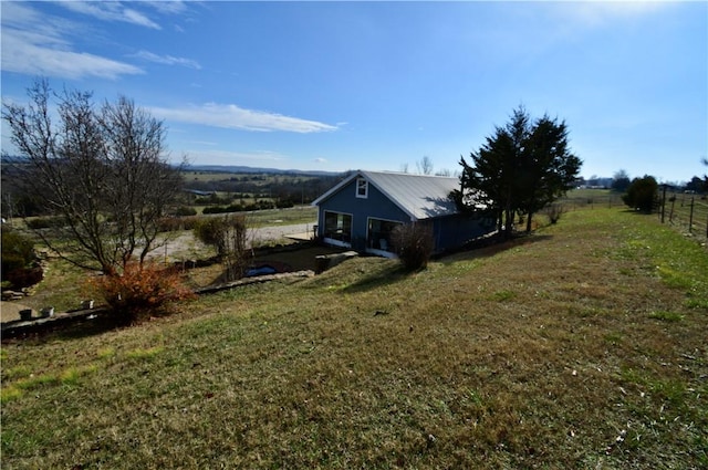 view of property exterior featuring a rural view and a lawn