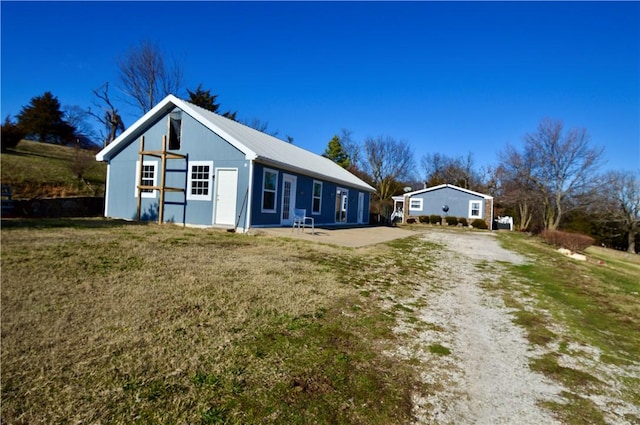 exterior space with a patio area, an outbuilding, and a front yard