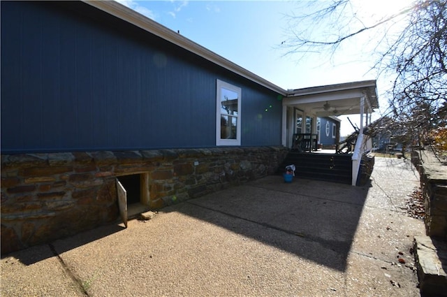 view of home's exterior with ceiling fan and a patio