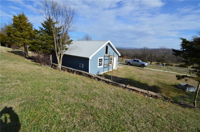 view of home's exterior with a yard and an outdoor structure