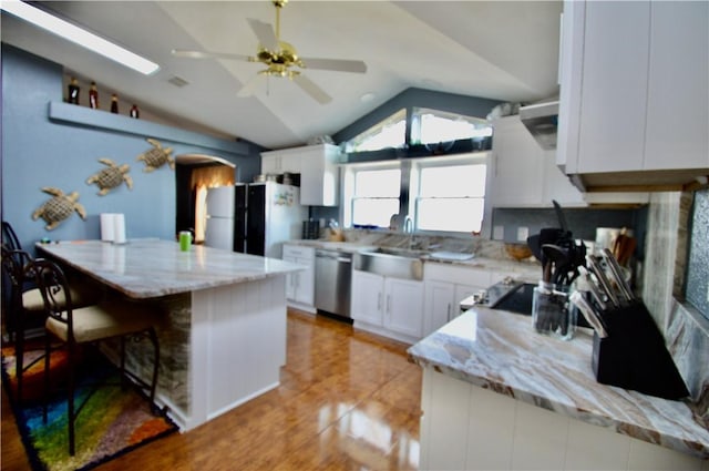 kitchen with white cabinets, dishwasher, light stone countertops, and lofted ceiling