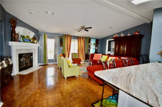 dining space featuring ceiling fan, lofted ceiling with beams, and wood-type flooring