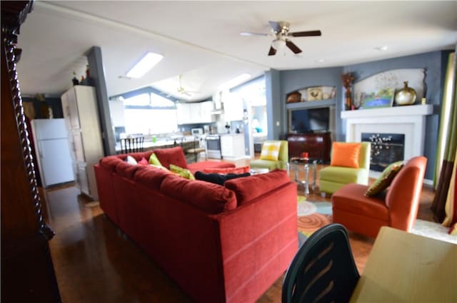 living room featuring ceiling fan, wood-type flooring, and vaulted ceiling