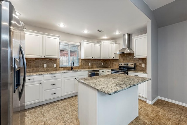 kitchen with white cabinetry, a center island, sink, wall chimney exhaust hood, and stainless steel appliances