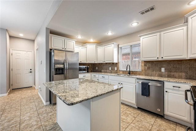 kitchen with white cabinets, sink, a kitchen island, and appliances with stainless steel finishes