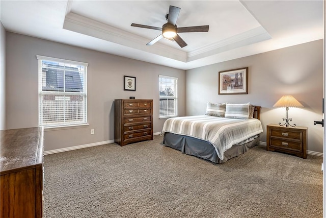 carpeted bedroom with ceiling fan, ornamental molding, and a tray ceiling