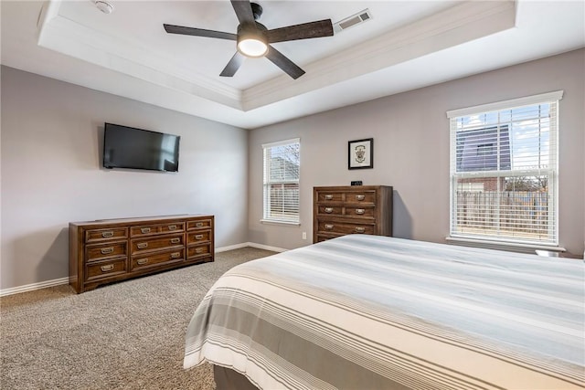 carpeted bedroom with a tray ceiling and ceiling fan