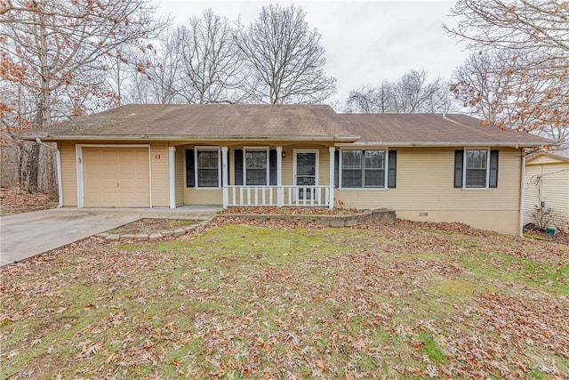 ranch-style home featuring covered porch, a front yard, and a garage