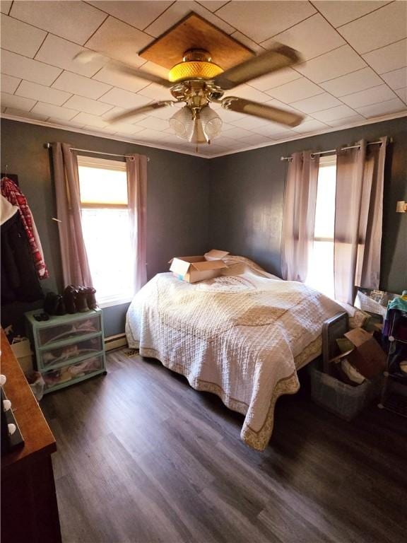 bedroom featuring multiple windows, dark hardwood / wood-style floors, ceiling fan, and crown molding