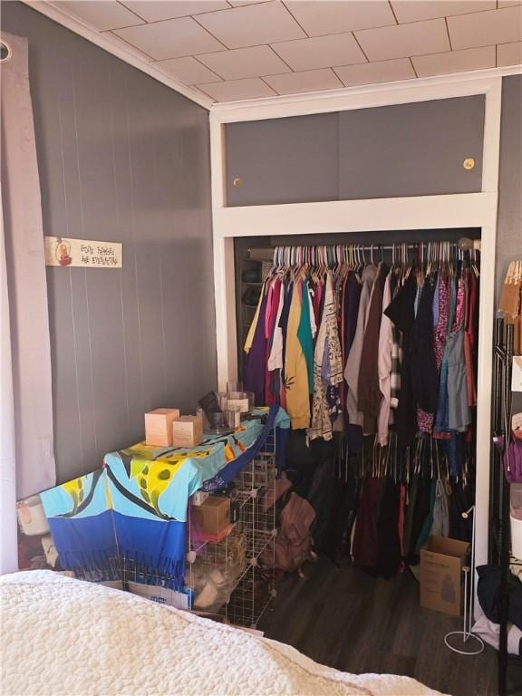 bedroom featuring wood-type flooring, a closet, and ornamental molding