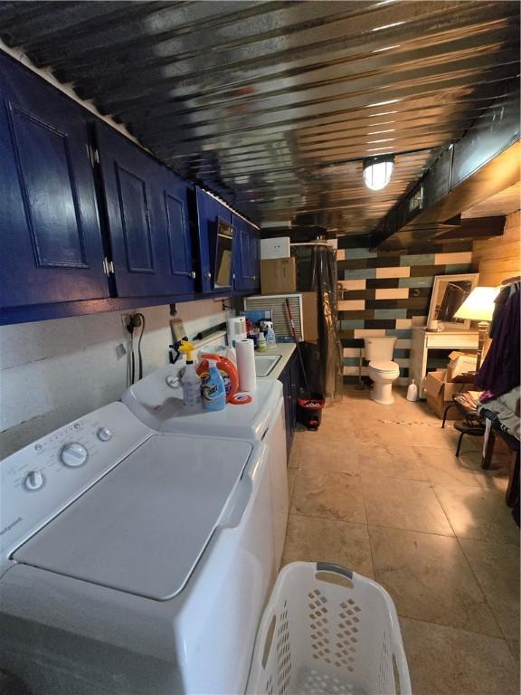 washroom with washing machine and clothes dryer and cabinets