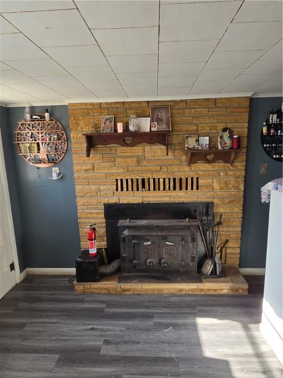 room details with hardwood / wood-style floors, a wood stove, and wooden walls