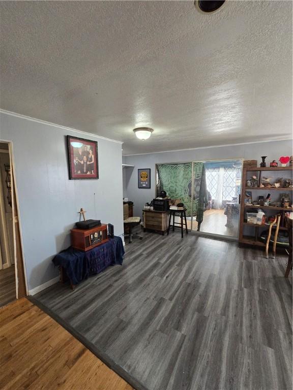 interior space featuring crown molding, dark hardwood / wood-style flooring, and a textured ceiling