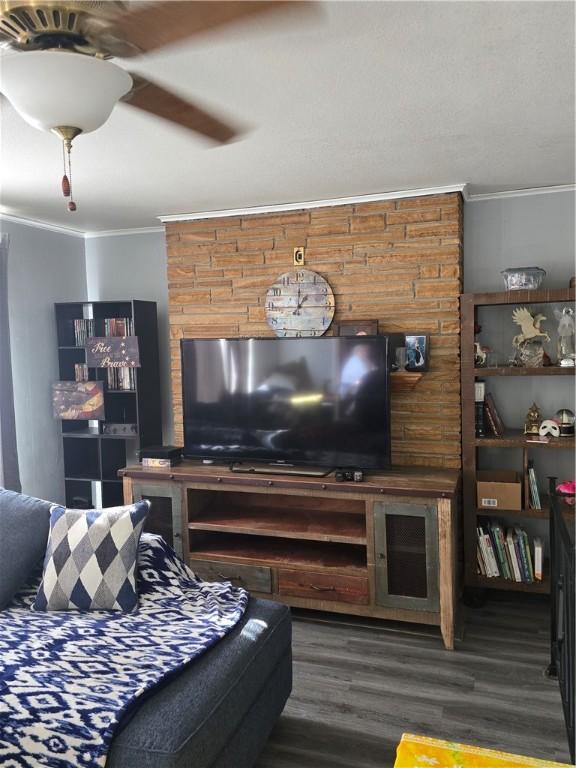 living room with crown molding and dark wood-type flooring