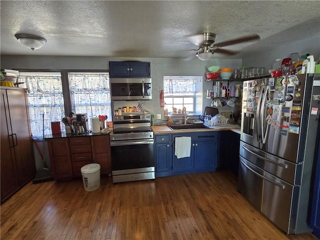 kitchen featuring sink, blue cabinets, dark hardwood / wood-style floors, and appliances with stainless steel finishes