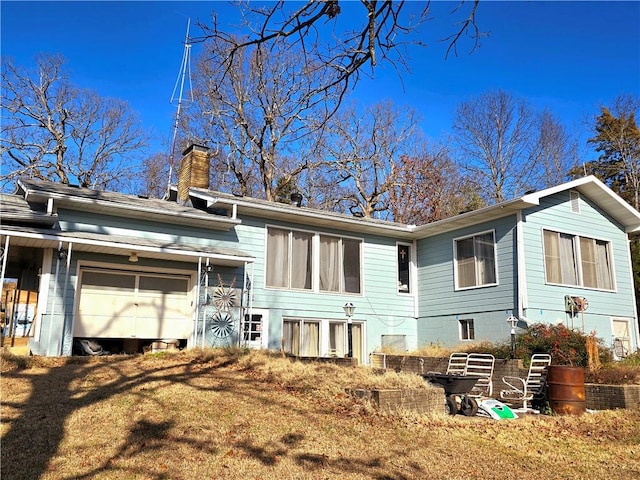 rear view of property with a garage