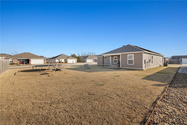 rear view of property with a lawn and a playground