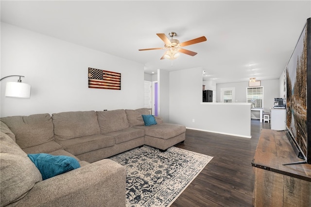 living room featuring ceiling fan and dark wood-type flooring