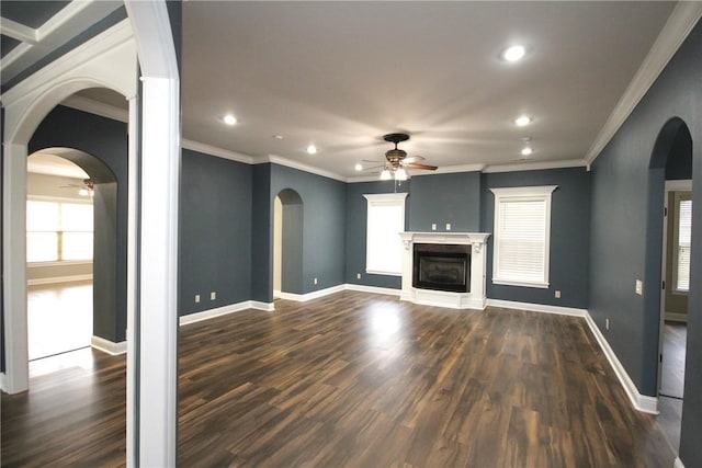 unfurnished living room featuring dark hardwood / wood-style floors, a wealth of natural light, crown molding, and ceiling fan