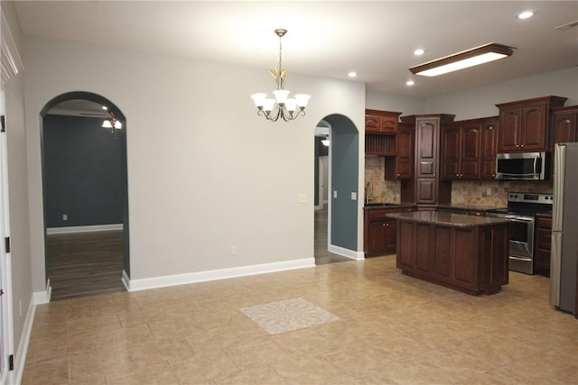 kitchen with dark brown cabinetry, tasteful backsplash, a chandelier, a kitchen island, and appliances with stainless steel finishes