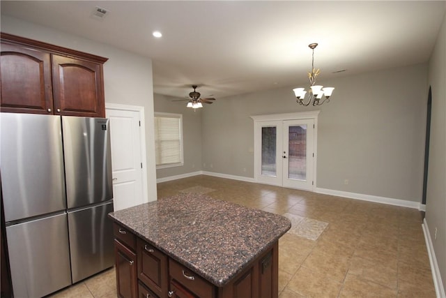 kitchen featuring ceiling fan with notable chandelier, stainless steel fridge, dark brown cabinets, and french doors