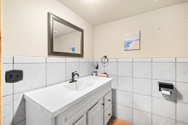 bathroom featuring vanity and tile walls