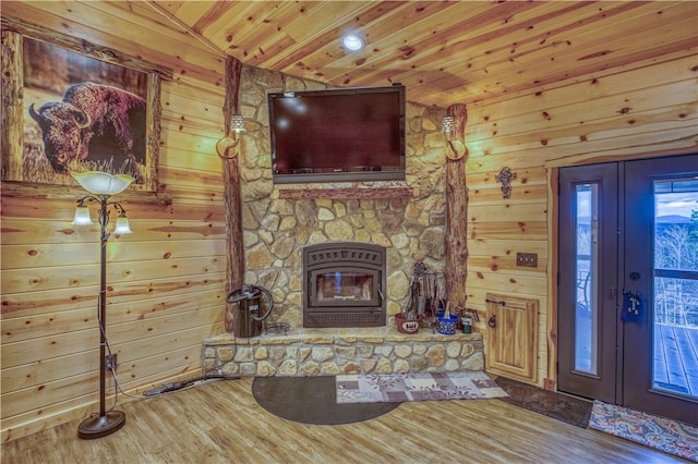 unfurnished living room with hardwood / wood-style floors, lofted ceiling, and wood walls