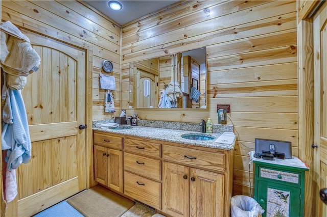 bathroom featuring vanity and wood walls