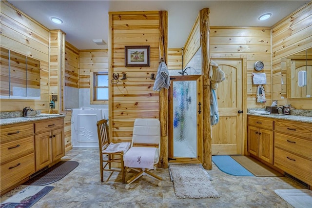 bathroom with vanity, wood walls, and washer / clothes dryer