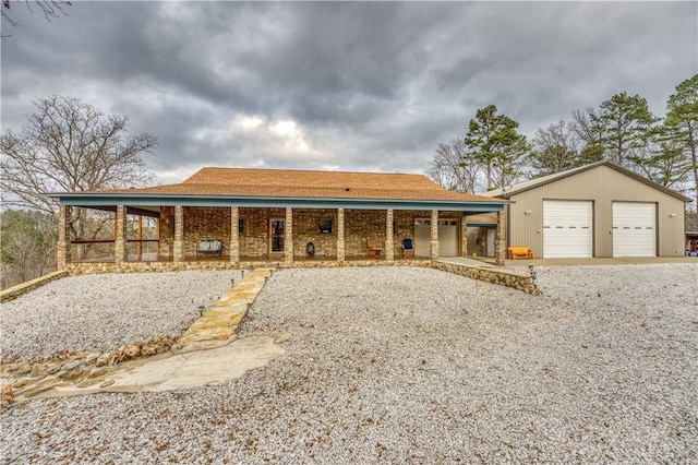 ranch-style house featuring a garage, covered porch, and an outbuilding