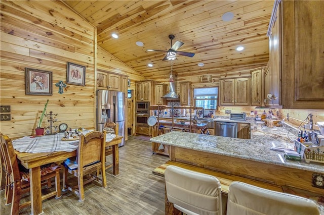 kitchen featuring lofted ceiling, light hardwood / wood-style flooring, kitchen peninsula, stainless steel appliances, and wood ceiling