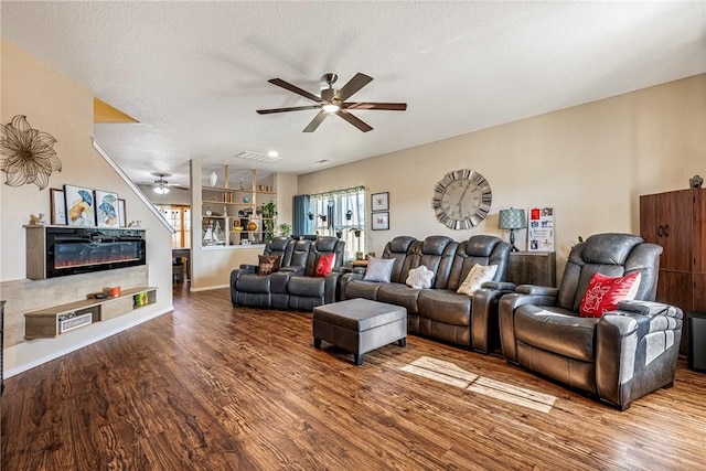 living room featuring hardwood / wood-style flooring, ceiling fan, a textured ceiling, and built in shelves