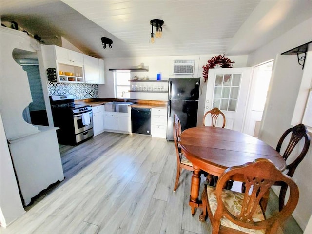 kitchen featuring white cabinetry, sink, tasteful backsplash, black appliances, and light wood-type flooring