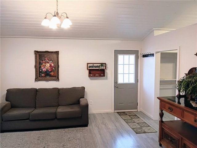 living room with a notable chandelier, wooden ceiling, ornamental molding, and light hardwood / wood-style flooring