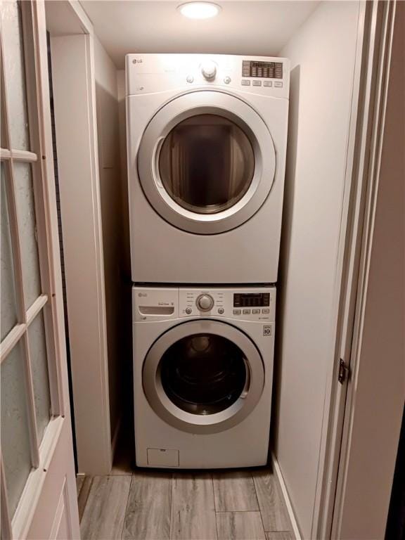 clothes washing area with stacked washer / dryer