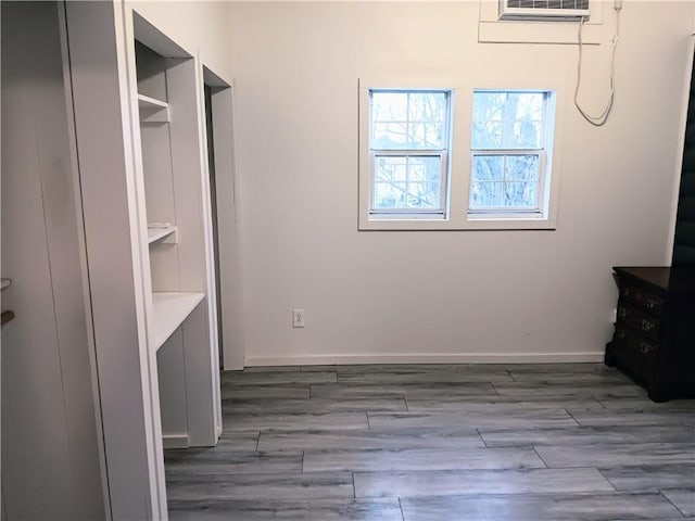 laundry room featuring a wall mounted air conditioner and dark wood-type flooring