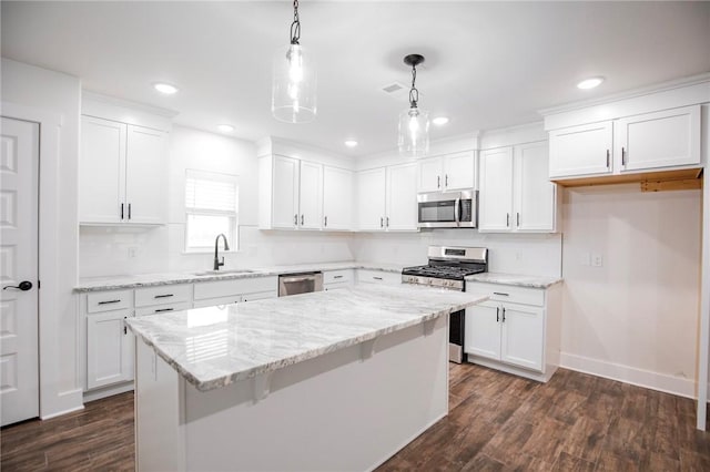 kitchen featuring white cabinetry, hanging light fixtures, and appliances with stainless steel finishes