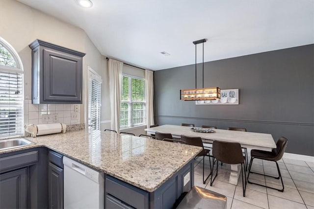 1515/1517 Belle Royal Ct, Bentonville, AR 72712 - kitchen featuring dishwasher, a peninsula, backsplash, light tile patterned floors, and decorative light fixtures